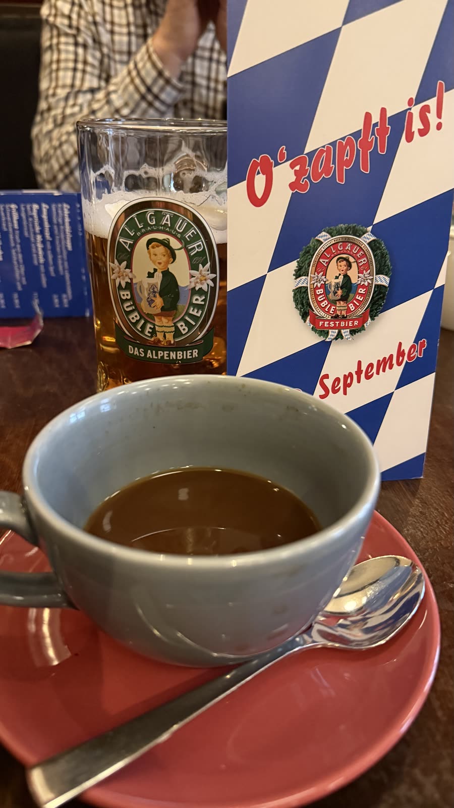 Kaffeetasse vor einem Oktoberfest-Wimpel mit der Aufschrift O'zapft is